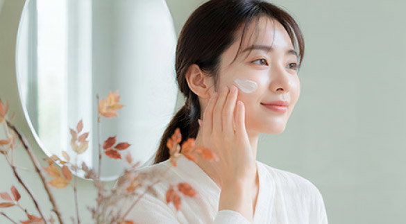 woman putting on moisturizer