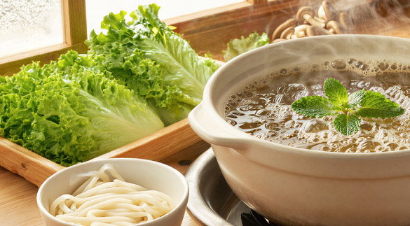 hot pot with fresh lettuce, udon noodles and mushrooms